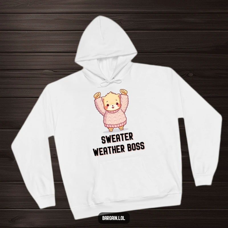 Funny hoodie: A small, fuzzy character triumphantly holding a huge, handmade knitted sweater, embodying cozy humor.