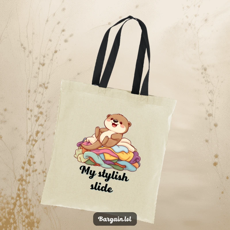 Funny tote bag showing a cute otter character gleefully sliding down a pile of colorful clothing, perfect for carrying essentials.
